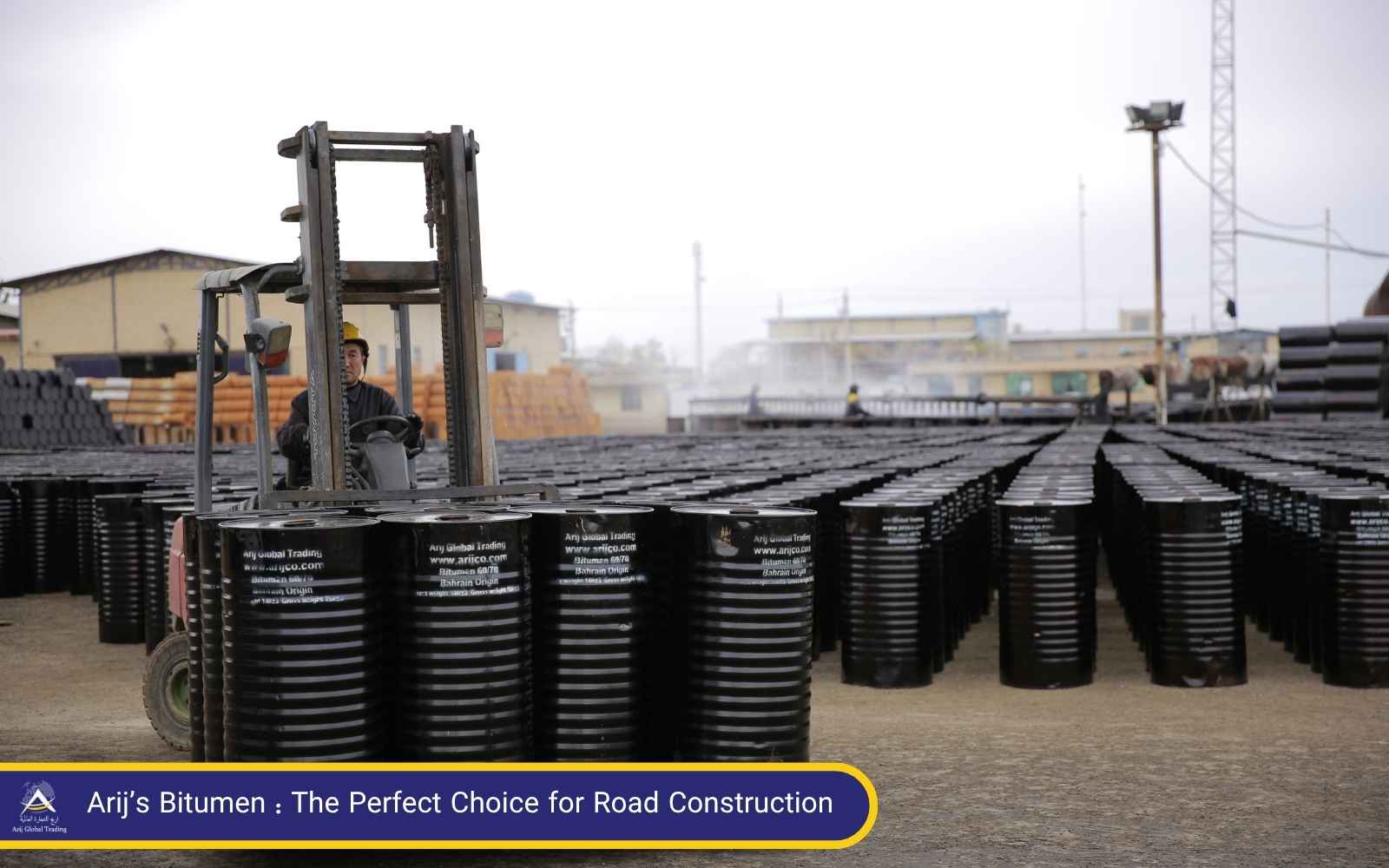 Arij Global Trading – Reliable Bitumen Trader for Highway Projects Forklift moving bitumen drums in a storage yard at Arij Global Trading, a leading bitumen trader and exporter for road construction