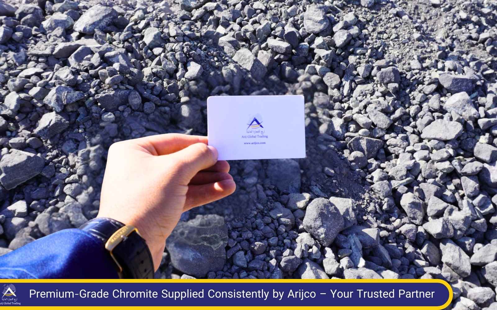 Arijco’s Chromite – Premium-Grade Material Inspected On-Site by a Leading Chromite Supplier Hand holding Arijco Global Trading card over chromite stockpile – highlighting the quality and consistency of Arijco’s Chromite from a trusted chromite supplier