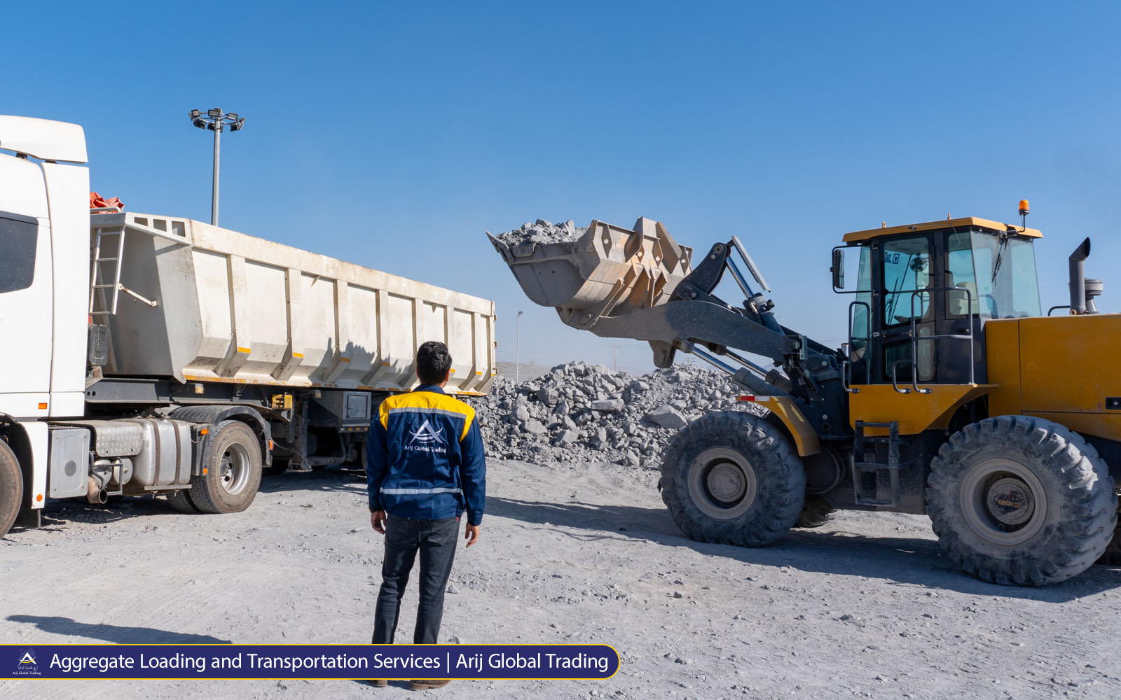Wheel loader loading crushed stone aggregates into dump truck at Arijco Global Trading quarry and construction materials site