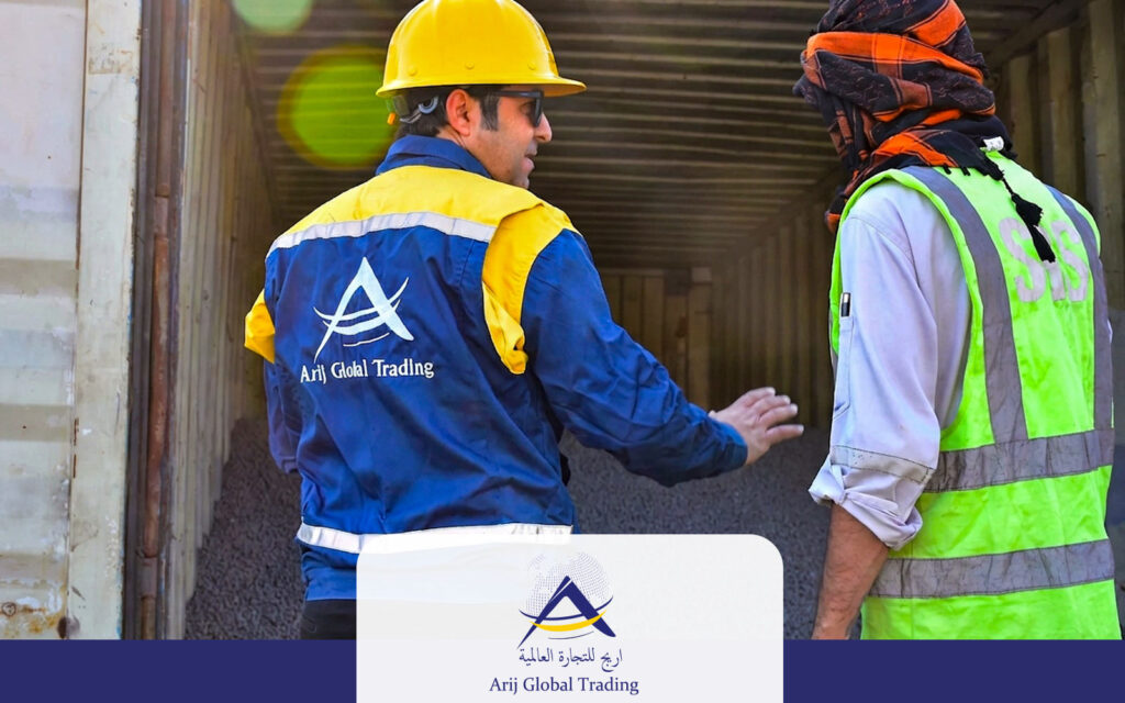 Quality inspection of Direct Reduced Iron (DRI) inside a shipping container by an Arij Global Trading representative wearing safety gear and discussing the cargo with an SGS inspector before export.
