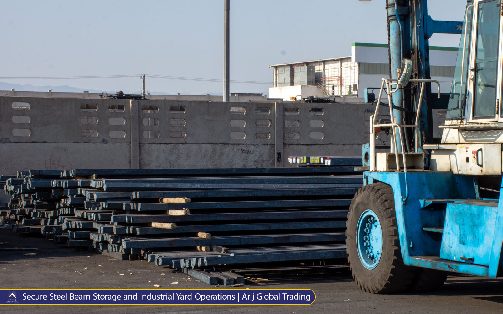 Secure Steel Beam Storage and Industrial Yard Operations | Arij Global Trading Blue industrial forklift beside stacked steel H-beams in an outdoor storage yard. Arij Global Trading steel inventory and material handling operations.