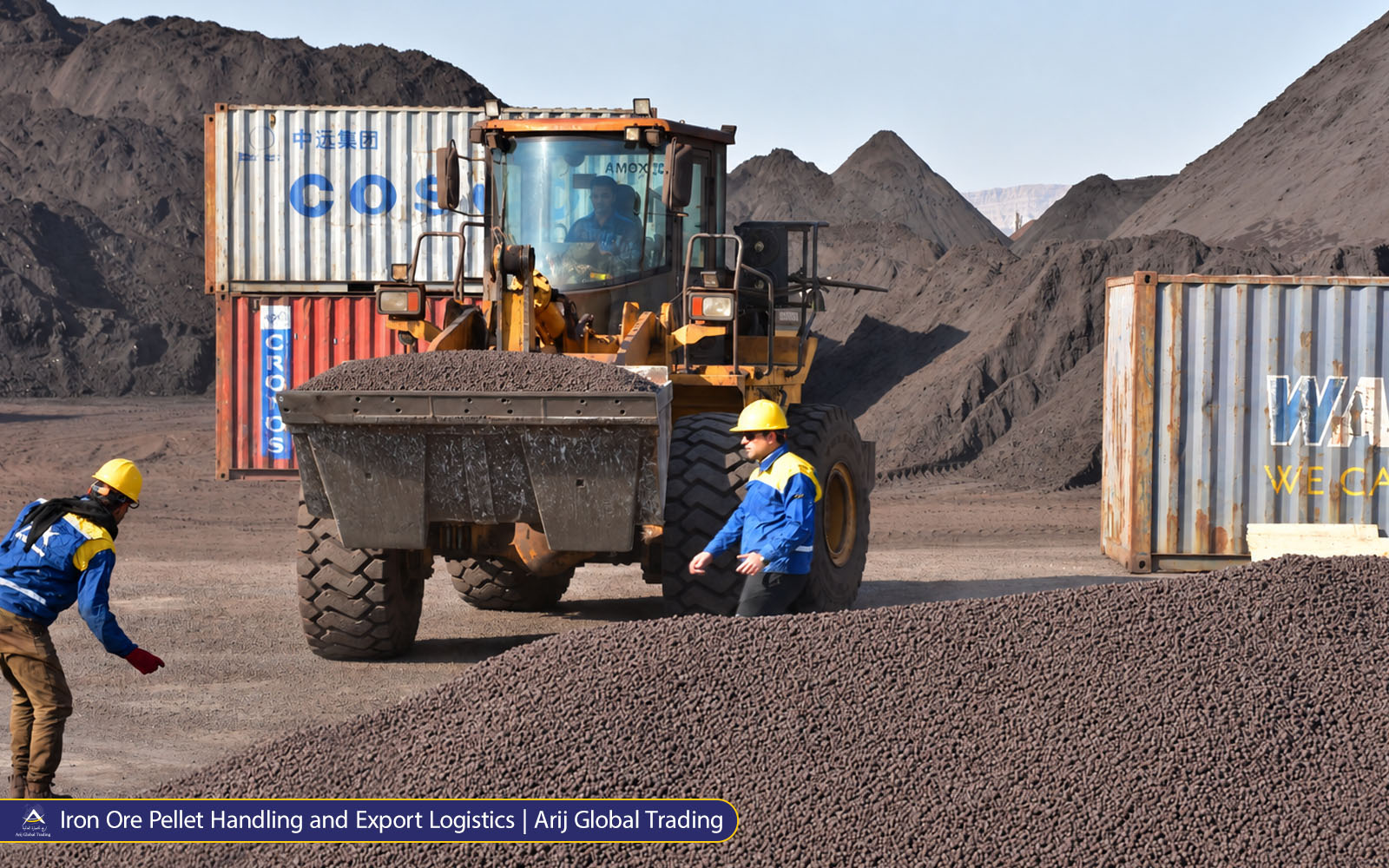 Iron Ore Pellet Handling and Export Logistics Arij Global Trading Iron ore pellets being handled by a front loader in an industrial stockyard with shipping containers and Arij Global Trading personnel.