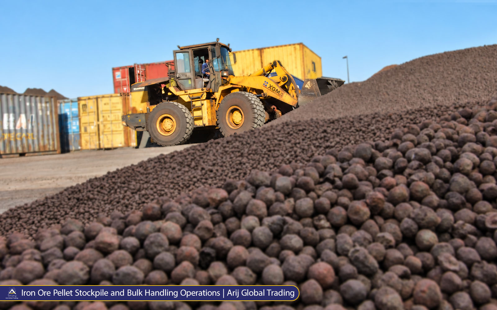 Iron Ore Pellet Stockpile and Bulk Handling Operations Wheel loader handling a large stockpile of iron ore pellets at a bulk export yard.