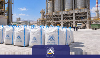 White jumbo bags of calcined dolomite with blue lifting straps at an industrial processing facility.